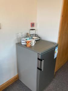 a small kitchen with a counter and a refrigerator at Pepper Street Rooms in Whitchurch