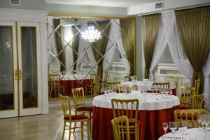 un comedor con mesas y sillas y una lámpara de araña en Grand Hotel Fortecia, en Orsk