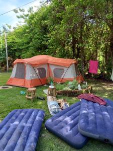 namiot i dwa materace wlewowe przed polem w obiekcie Pousada e Camping Daniel w mieście São Roque de Minas
