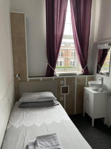 1 dormitorio con cama, lavabo y ventana en Bentleys, en Newcastle