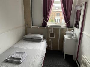 a small room with a bed and a sink at Bentleys in Newcastle upon Tyne