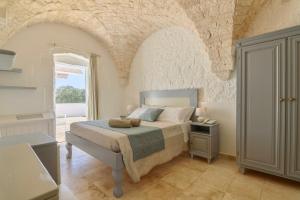 a bedroom with a bed with a teddy bear on it at Masseria Ayroldi in Ostuni +131 photos