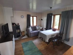 ein Wohnzimmer mit einem Sofa und einem Tisch in der Unterkunft Old Finnish lakeside cottage with sauna in Oulu