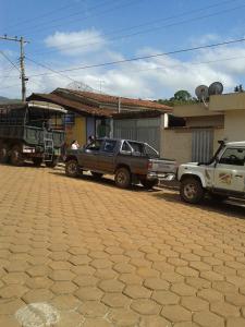 a group of vehicles parked in front of a building at Pousada e Camping Daniel in São Roque de Minas
