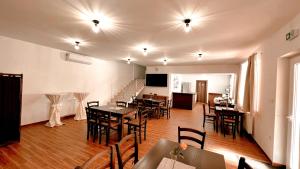 une salle à manger avec des tables, des chaises et des lumières dans l'établissement Penzión MELIS, à Trebišov