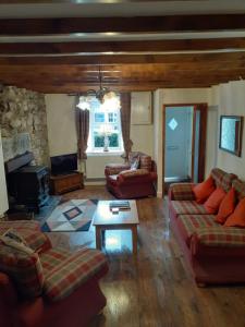 a living room with two couches and a table at bryn cilio in Beddgelert