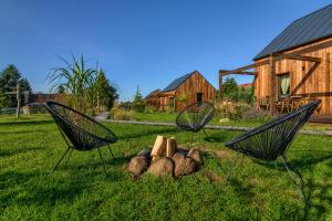 two chairs with a fire pit in the grass at Pod mazurskim niebem dom rustykalny in Piecki