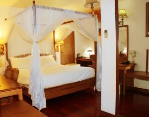 ein Schlafzimmer mit einem Himmelbett in der Unterkunft Sunny Garden in Antananarivo