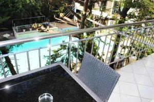 einen Balkon mit einem Stuhl und einem Pool in der Unterkunft Sunny Garden in Antananarivo