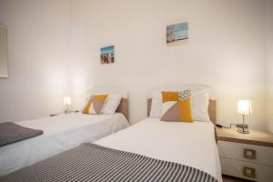 Dos camas una al lado de la otra en un dormitorio. en Mango Apartments, en Torre Lapillo