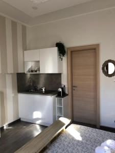 ヴェローナにあるRooms Giulietta e Romeoの白いキャビネットと木製のドア付きのキッチン