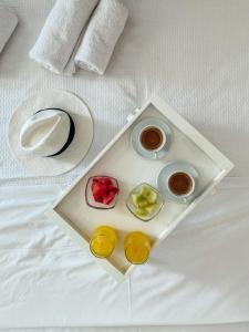 a tray of food on a bed with a plate of food at Aperitton Hotel in Skopelos Town