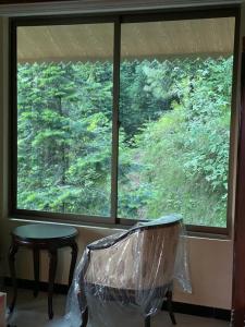 a room with a window with a chair and a table at Richmond Boutique Hotel in Nathia Gali