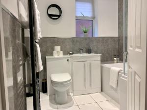 a bathroom with a toilet and a sink and a tub at Stamer House by YourStays, Stylish quirky house, with 4 double bedrooms, BOOK NOW! in Stoke on Trent