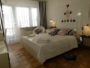 1 dormitorio con 1 cama blanca grande con almohadas en Apartament BB Źródlana, en Krynica-Zdrój
