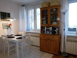 cocina con mesa, sillas y armario en Apartament BB Źródlana, en Krynica-Zdrój