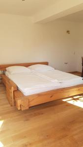 een groot houten bed in een kamer met houten vloeren bij Belka am Rursee in Simmerath