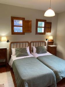 1 Schlafzimmer mit 2 Betten und 2 Fenstern in der Unterkunft El Verderín de Onón in Gijón