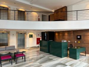 un hall avec un bar et des chaises dans un bâtiment dans l'établissement QS Marista Hotel, à Goiânia