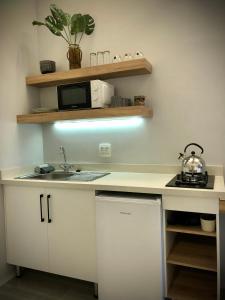 a white kitchen with a sink and a microwave at Modern Goldfields Apartments in Virginia
