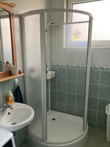W łazience znajduje się prysznic i umywalka. w obiekcie Sunhouse, Balatonvilágos w mieście Balatonvilágos