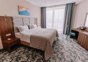 a hotel room with a large bed and a desk at Grand Hotel Anapa in Anapa