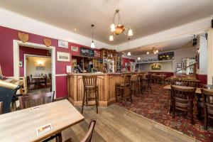 a bar in a restaurant with wooden tables and chairs at The Black Horse in Swaffham Bulbeck