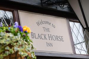 un panneau indiquant la bienvenue à l'auberge de chevaux noirs dans l'établissement The Black Horse, à Swaffham Bulbeck