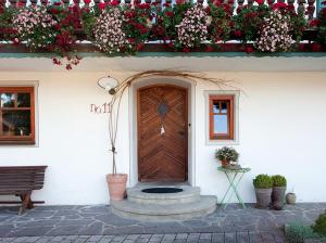 een huis met een houten deur met bloemen erop bij Stachl-Hof - Chiemgau Karte in Inzell