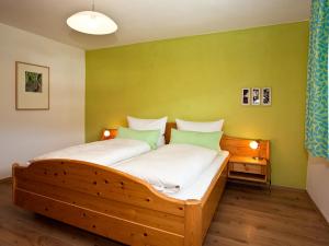 a bedroom with a wooden bed with green walls at Stachl-Hof - Chiemgau Karte in Inzell