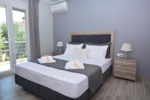 sypialnia z dużym łóżkiem i 2 ręcznikami w obiekcie Blue North Luxury Apartment w mieście Limenas