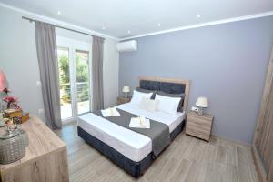 sypialnia z łóżkiem i dużym oknem w obiekcie Blue North Luxury Apartment w mieście Limenas