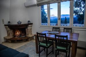 une salle à manger avec une table et une cheminée dans l'établissement Priamos Kalitehnoupoli, à Rafína