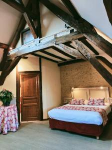 ein Schlafzimmer mit einem großen Bett im Dachgeschoss in der Unterkunft La Chaumière in Aubigny-sur-Nère
