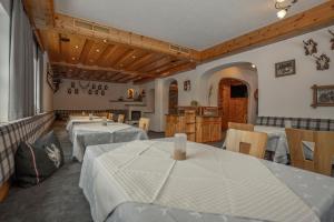 a restaurant with tables and chairs and a kitchen at Gasthof Waldesruh in Oetz