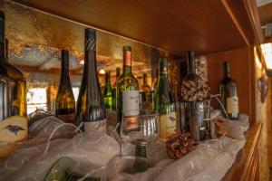 a bunch of wine bottles and glasses on a shelf at Gasthof Waldesruh in Oetz