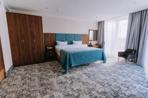 a hotel room with a bed and a chair at Grand Hotel Anapa in Anapa