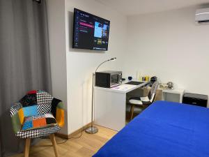 a room with a bed and a desk with a tv at Chambre d'hôtes indépendante de Pouzatel in Fumel