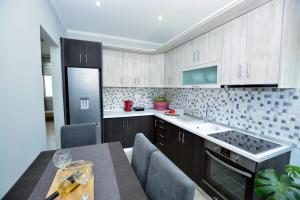 kuchnia z drewnianymi szafkami i stołem z krzesłami w obiekcie Blue North Luxury Apartment w mieście Limenas