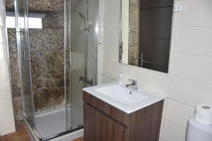 La salle de bains est pourvue d'un lavabo et d'une douche. dans l'établissement DIGNUS HOUSE, à Folhadosa