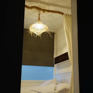 einen Kronleuchter über einem Bett in einem Schlafzimmer in der Unterkunft Bali Beach in Zandvoort