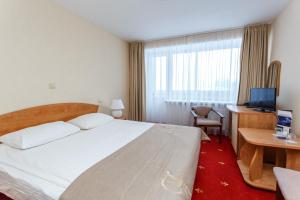 a hotel room with a bed and a desk and a television at AMAKS Valdaiskie Zori in Valday