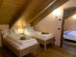 a room with two beds in a attic at Baita Pomo in Livigno