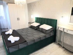 a green bed with two pillows on it in a room at CASTEL in Mali Lošinj