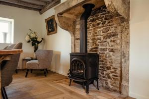 sala de estar con chimenea y pared de piedra en Clos des Dames de Lancharre, en Chapaize