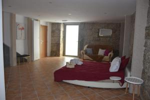 - une chambre avec un grand lit et un couvre-lit rouge dans l'établissement DIGNUS HOUSE, à Folhadosa
