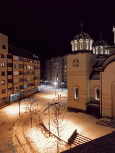 a building with a domed tower in the snow at night at Apartman Mia in Pale
