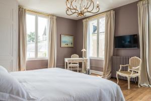 sypialnia z białym łóżkiem i 2 oknami w obiekcie La Dixmeresse w mieście Restigné