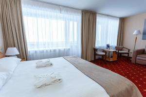 a hotel room with a large bed with towels on it at AMAKS Valdaiskie Zori in Valday