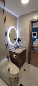 a bathroom with a toilet and a sink and a mirror at Suite de Lujo, Piso Alto, junto Parque Carolina, Generador electrico in Quito +33 photos